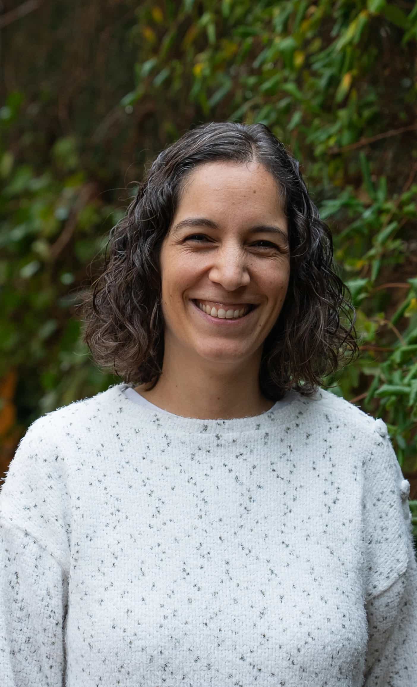 Imagen de una mujer mirando al frente sonriendo.