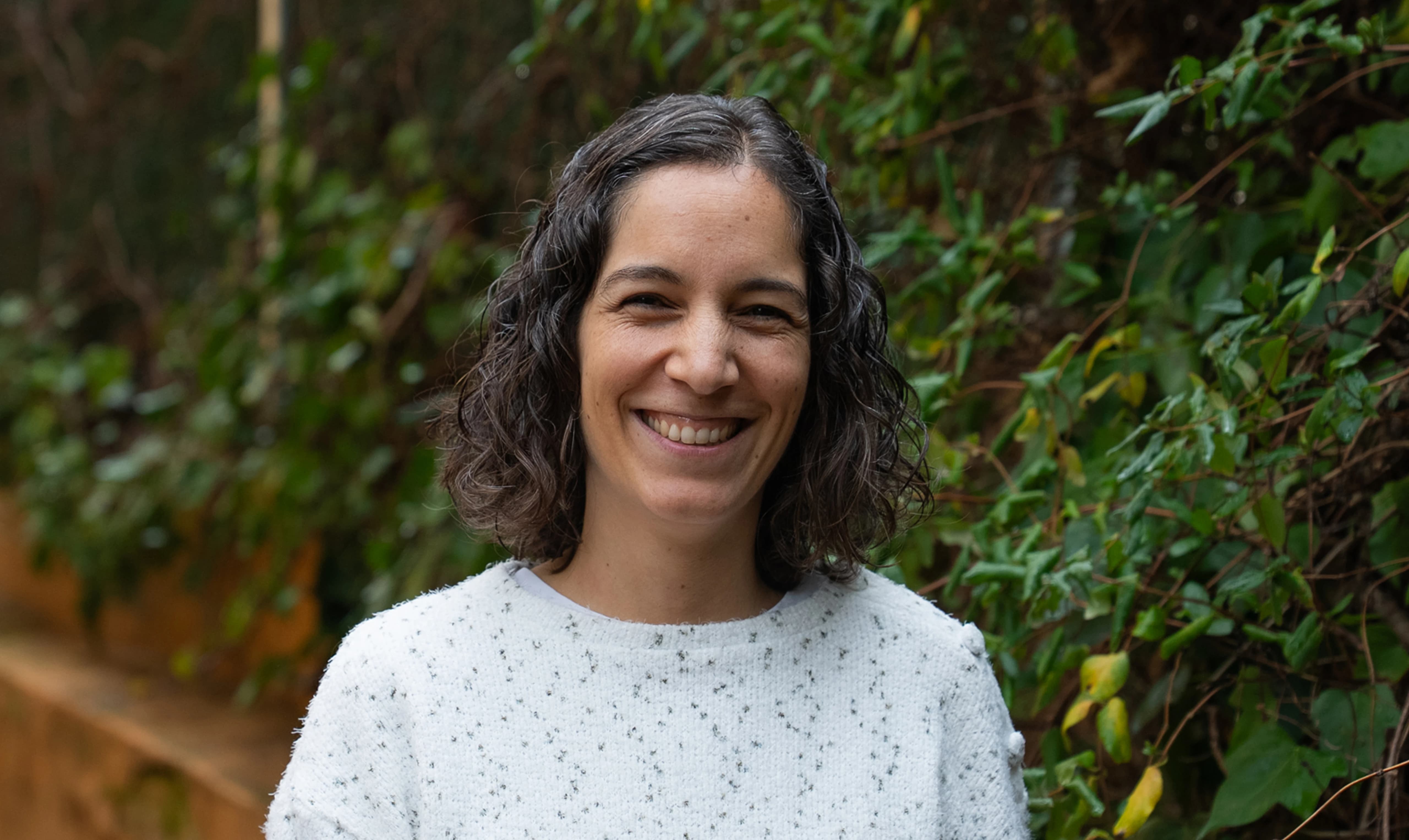 Imagen de una mujer mirando al frente sonriendo.
