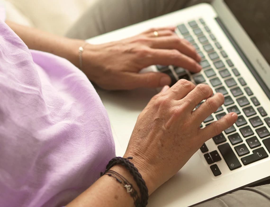 Imagen de una persona escribiendo en un portátil.