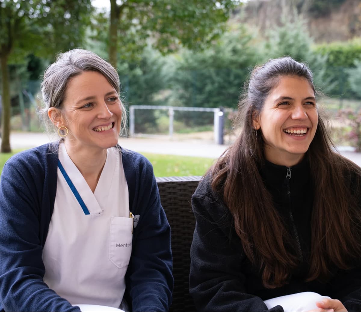 Imagen de dos mujeres hablando sentadas en un sofá.