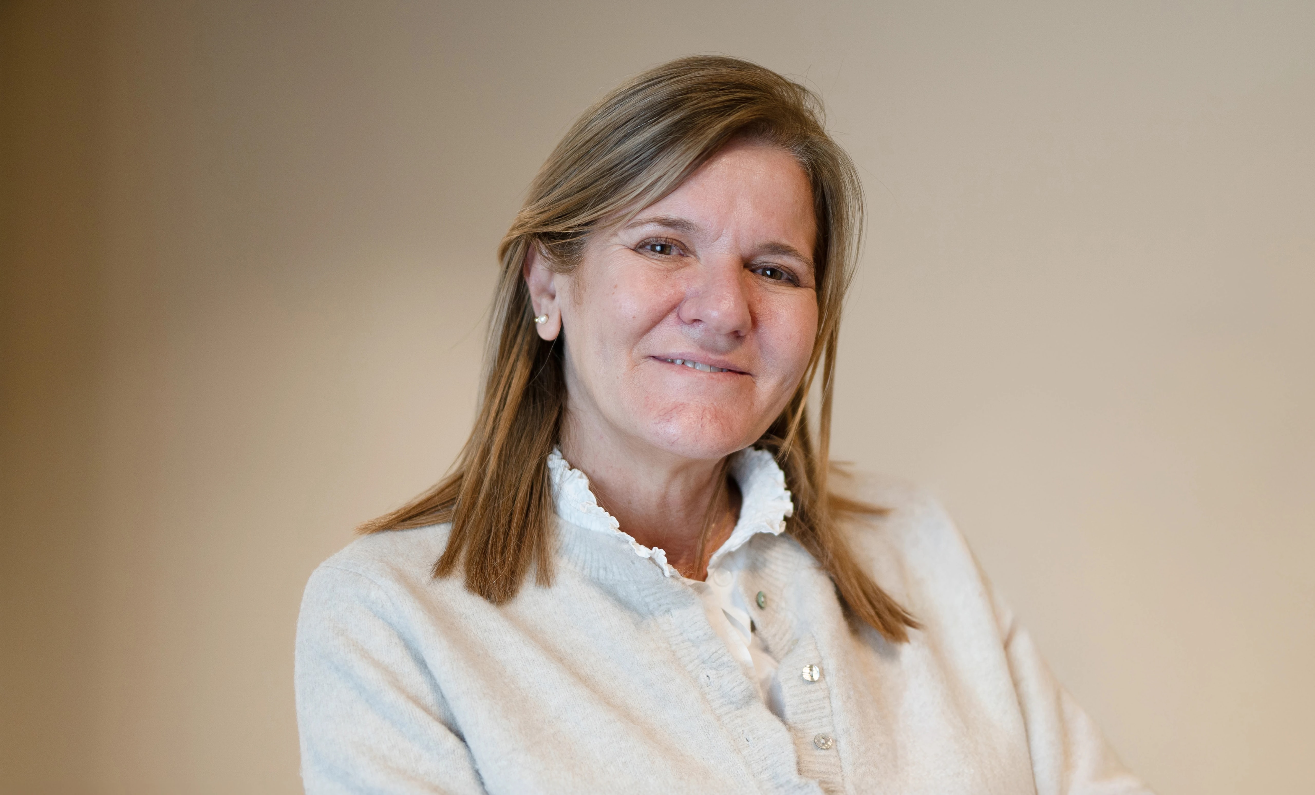 Imagen de una mujer mayor mirando a cámara sonriendo.