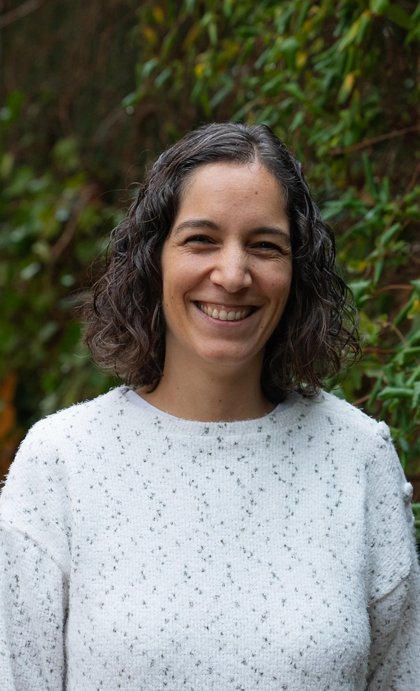 Imagen de una mujer mirando al frente sonriendo.